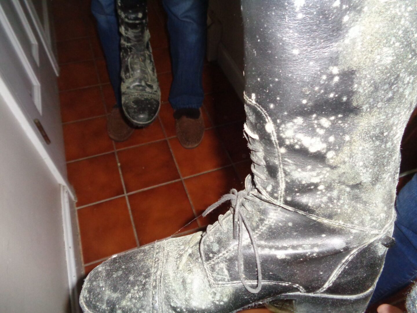 A person wearing silver boots and jeans